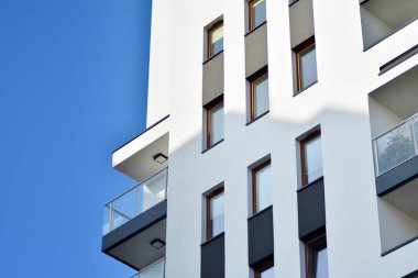 Mavi gökyüzü olan güneşli bir günde modern apartman binaları. Modern bir apartmanın cephesi