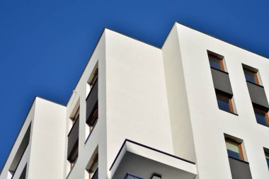 Mavi gökyüzü olan güneşli bir günde modern apartman binaları. Modern bir apartmanın cephesi