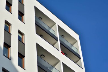 Mavi gökyüzü olan güneşli bir günde modern apartman binaları. Modern bir apartmanın cephesi