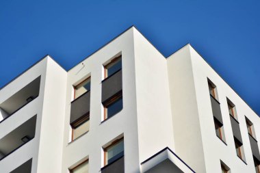 Mavi gökyüzü olan güneşli bir günde modern apartman binaları. Modern bir apartmanın cephesi