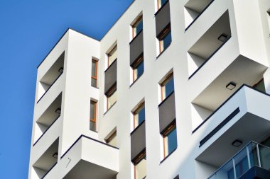 Mavi gökyüzü olan güneşli bir günde modern apartman binaları. Modern bir apartmanın cephesi