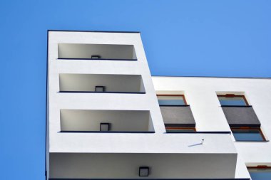 Mavi gökyüzü olan güneşli bir günde modern apartman binaları. Modern bir apartmanın cephesi