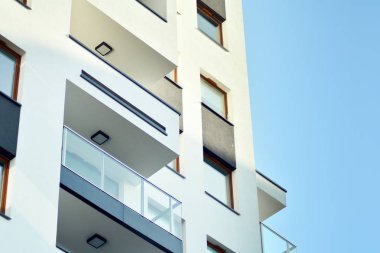 Mavi gökyüzü olan güneşli bir günde modern apartman binaları. Modern bir apartmanın cephesi