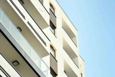 Mavi gökyüzü olan güneşli bir günde modern apartman binaları. Modern bir apartmanın cephesi