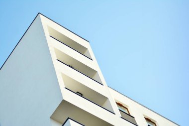 Mavi gökyüzü olan güneşli bir günde modern apartman binaları. Modern bir apartmanın cephesi