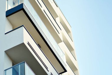 Mavi gökyüzü olan güneşli bir günde modern apartman binaları. Modern bir apartmanın cephesi