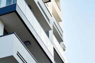 Mavi gökyüzü olan güneşli bir günde modern apartman binaları. Modern bir apartmanın cephesi