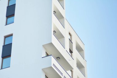 Mavi gökyüzü olan güneşli bir günde modern apartman binaları. Modern bir apartmanın cephesi
