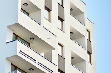 Mavi gökyüzü olan güneşli bir günde modern apartman binaları. Modern bir apartmanın cephesi