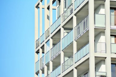 Mavi gökyüzü olan güneşli bir günde modern apartman binaları. Modern bir apartmanın cephesi