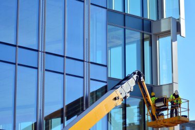 Site oluşturma, yükseklik üzerinde kafes kaldırma iki inşaat işçileri. İnşaat İşçileri.