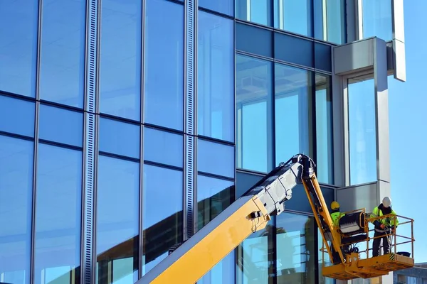 Site oluşturma, yükseklik üzerinde kafes kaldırma iki inşaat işçileri. İnşaat İşçileri.