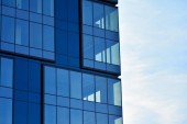 Nová kancelářská budova v obchodním centru. Zeď z oceli a skla s modrou oblohou. 