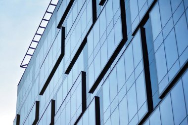 İş merkezindeki yeni ofis binası. Çelikten ve camdan yapılmış mavi gökyüzü. 