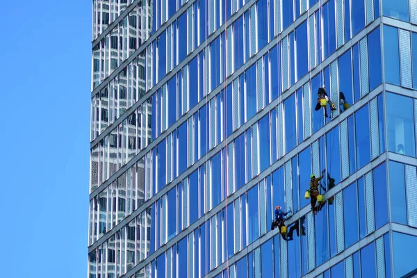 登山者洗窗户和玻璃幕墙的摩天大楼 — 图库照片