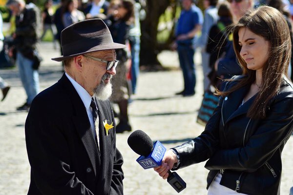 Warsaw, Poland. 19 April 2019. Female journalist TVP with microphone interviewing. 