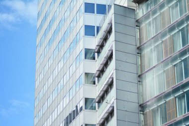 İş merkezindeki yeni ofis binası. Çelikten ve camdan yapılmış mavi gökyüzü. 