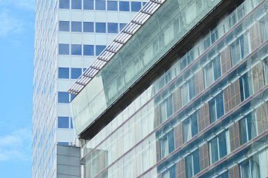 İş merkezindeki yeni ofis binası. Çelikten ve camdan yapılmış mavi gökyüzü. 