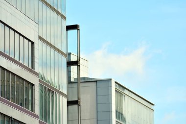 İş merkezindeki yeni ofis binası. Çelikten ve camdan yapılmış mavi gökyüzü. 