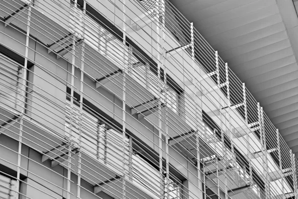 Facade fragment of a modern office building. Exterior of glass wall with abstract texture. Black and white.