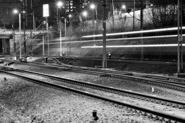 Gece tren raylarında yolcu treni - bulanık hareket. Siyah beyaz