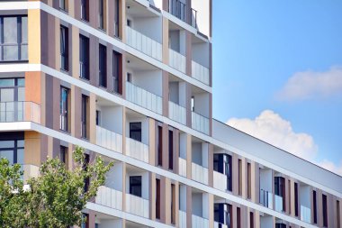 Mavi gökyüzü olan güneşli bir günde modern apartman binaları. Modern bir apartmanın cephesi