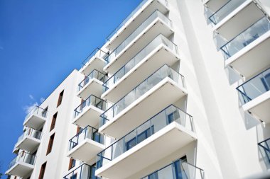 Mavi gökyüzü olan güneşli bir günde modern apartman binaları. Modern bir apartmanın cephesi