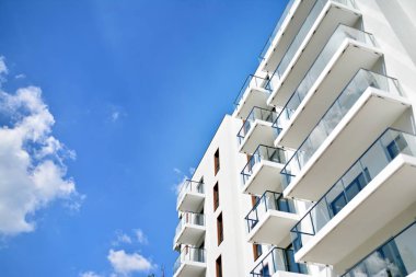 Mavi gökyüzü olan güneşli bir günde modern apartman binaları. Modern bir apartmanın cephesi