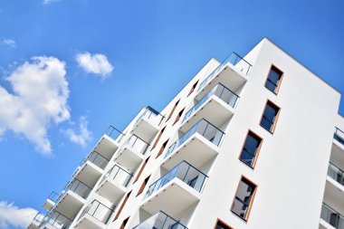 Mavi gökyüzü olan güneşli bir günde modern apartman binaları. Modern bir apartmanın cephesi