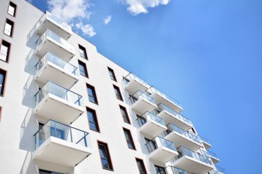 Mavi gökyüzü olan güneşli bir günde modern apartman binaları. Modern bir apartmanın cephesi