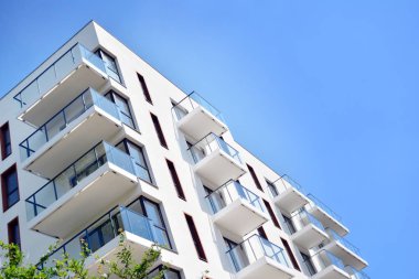 Mavi gökyüzü olan güneşli bir günde modern apartman binaları. Modern bir apartmanın cephesi