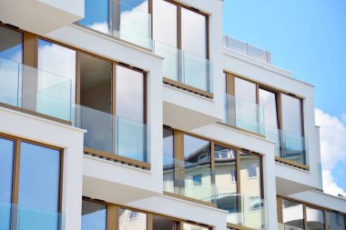 Mavi gökyüzü olan güneşli bir günde modern apartman binaları. Modern bir apartmanın cephesi
