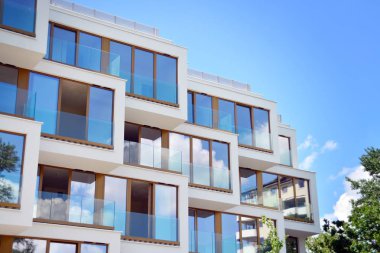 Mavi gökyüzü olan güneşli bir günde modern apartman binaları. Modern bir apartmanın cephesi