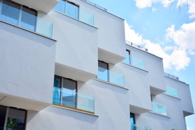Mavi gökyüzü olan güneşli bir günde modern apartman binaları. Modern bir apartmanın cephesi