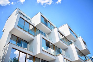 Mavi gökyüzü olan güneşli bir günde modern apartman binaları. Modern bir apartmanın cephesi