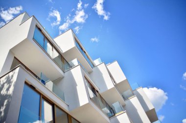 Mavi gökyüzü olan güneşli bir günde modern apartman binaları. Modern bir apartmanın cephesi