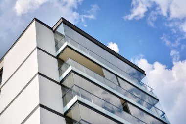 Mavi gökyüzü olan güneşli bir günde modern apartman binaları. Modern bir apartmanın cephesi