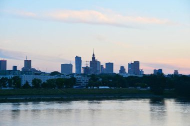 Nehir içinde belgili tanımlık geçmiş renkli batımında şehirde