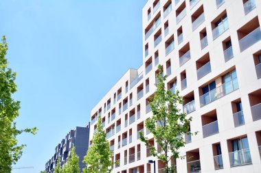 Mavi gökyüzü olan güneşli bir günde modern apartman binaları. Modern bir apartmanın cephesi