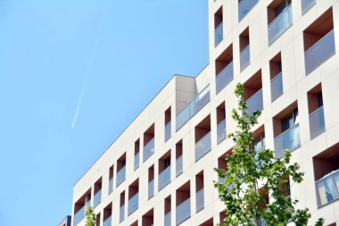 Mavi gökyüzü olan güneşli bir günde modern apartman binaları. Modern bir apartmanın cephesi