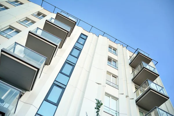 Mavi gökyüzü olan güneşli bir günde modern apartman binaları. Modern bir apartmanın cephesi