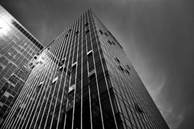 Geceleri gökdelenin siyah cam silueti. Gökdelenlerin kasvetli şehri. Siyah beyaz.