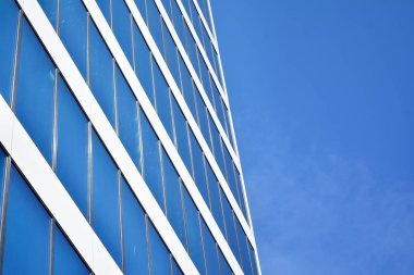 İş merkezindeki yeni ofis binası. Çelikten ve camdan yapılmış mavi gökyüzü. 