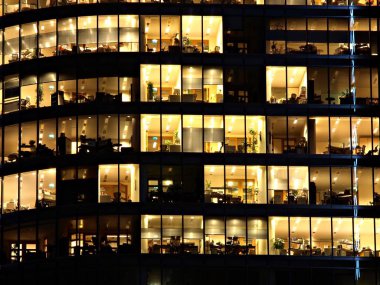 Ofis Binası geceleri. Geç gece iş yerinde. Cam perde duvar ofis binası