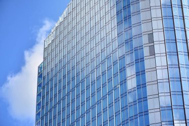 İş merkezindeki yeni ofis binası. Çelikten ve camdan yapılmış mavi gökyüzü. 