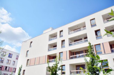 Mavi gökyüzü ve bulutlar ile modern daire binası. Modern çok katlı lüks konut konsepti.