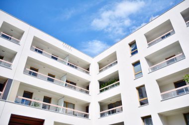 Mavi gökyüzü ve bulutlar ile modern daire binası. Modern çok katlı lüks konut konsepti.