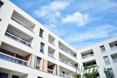 Mavi gökyüzü ve bulutlar ile modern daire binası. Modern çok katlı lüks konut konsepti.