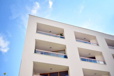 Mavi gökyüzü ve bulutlar ile modern daire binası. Modern çok katlı lüks konut konsepti.