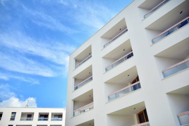 Mavi gökyüzü ve bulutlar ile modern daire binası. Modern çok katlı lüks konut konsepti.